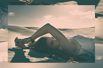 Image showing Woman, fashion and dune in desert for portrait with edgy style, dress and mystery in nature with sunshine. Girl, person and model with lying on sand, hill and outdoor with confidence in summer