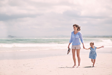 Image showing Mother, child and hand holding on beach travel or explore environment or windy summer or holiday, weekend or bonding. Female person, daughter and relax at Australia seaside or peace, vacation or trip