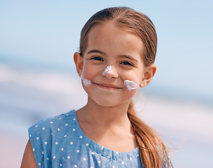 Image showing Child, portrait and smile with sunscreen on beach or summer protection or travel adventure, safety or holiday. Female person, girl and face or skincare lotion in Australia for vacation, break or trip