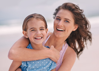 Image showing Happy mother, portrait and child with hug at beach for love, support or care in outdoor bonding, holiday or weekend in nature. Face of mom and young daughter with smile for embrace on the ocean coast