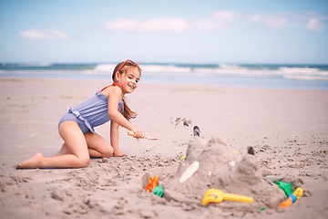 Image showing Happy girl, toys and playing with beach sand, castle or summer fun on outdoor holiday or weekend in nature. Female person, child or kid with smile for water or building sandcastle by ocean coast