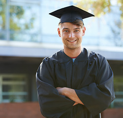 Image showing Graduation, student and portrait of man at university for learning, achievement and studying on campus. Education, academy and person with crossed arms for celebration, graduate ceremony and college