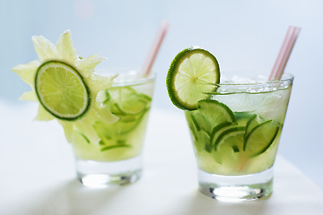 Image showing Cocktail, alcohol and mojito with lime for drink on table for party, club and bar or restaurant. Glass, background and closeup of mocktail, beverage and liquid with fruit, ice and liquor for drinking