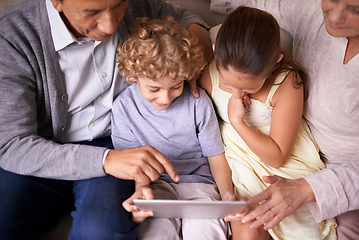 Image showing Family, children and grandparents pointing with tablet for entertainment or social media on sofa at home. Grandma, grandpa and showing kids interaction with technology for bonding or game at house