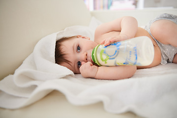 Image showing Baby, bottle and relax with boy, calm and nutrition with wellness and childcare with blanket. Home, kid and newborn drinking milk with growth and development with peace and joyful with formula