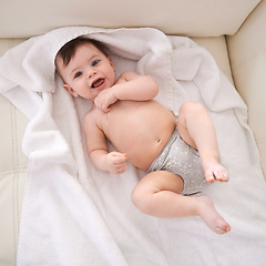 Image showing Portrait, baby and boy with diaper, top view and smile with blanket or relaxing with happiness. Face, infant or child with newborn or laugh with wellness or healthy with nappy or joy with kid or home