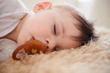 Image showing Baby, sleeping and pacifier with relax in home for healthy development, growth and tired in bedroom. Child, rest and dummy in mouth with nap, dreaming and wellness in nursery of house or apartment