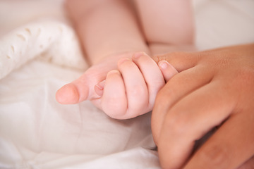 Image showing Bed, holding hands and parent with infant, wellness and support with maternity, health and bonding at home. Fingers, family and love with baby, protection and childcare with love, closeup or relaxing