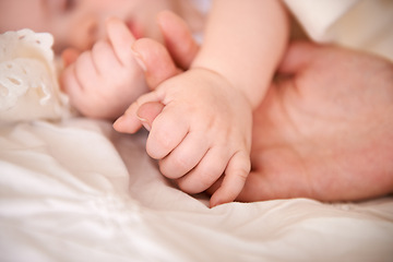 Image showing Bed, holding hands and parent with infant, care and support with maternity, health and wellness at home. Fingers, family and love with a healthy baby, protection and child development with bonding
