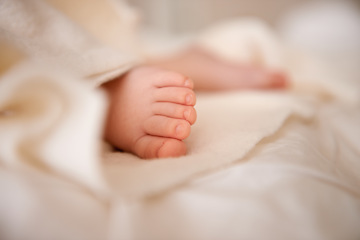 Image showing Baby, feet and toes or blanket as closeup for childhood development or nursery sleeping, relax or resting. Kid, wellness and childcare on bed for wellbeing nap or dreaming nurture, caring or calm