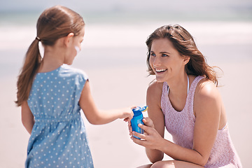 Image showing Happy mother, girl and sunscreen bottle at beach for summer holiday, vacation or travel. Child, kid and mom apply sunblock cream outdoor for protection, health or skincare of family laughing together