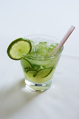 Image showing Cocktail, alcohol and glass with lime for mojito drink on table for party, club and bar. Mockup, background and closeup of mocktail, beverage and liquid with fruit, ice and liquor for celebration