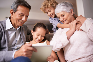 Image showing Happy family, grandparents and children with tablet on sofa for entertainment or social media at home. Grandma, grandpa and kids with smile, hug and love on technology for bonding or game at house