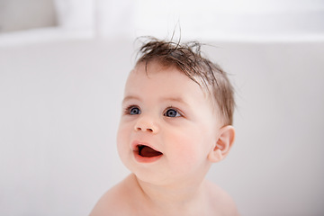Image showing Happy, cute and baby in bathtub at house for infant hygiene, health and wellness routine. Sweet, smile and adorable young boy toddler, child or kid washing body for clean skin in bathroom at home.