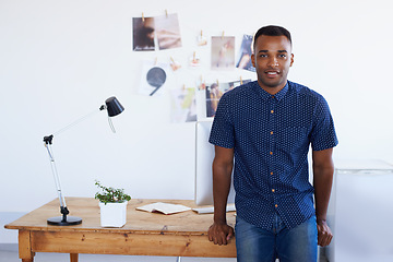 Image showing Man, portrait and desk at creative studio or startup as .graphic designer with photographs, project planning or magazine. Male person, face and confidence or small business, entrepreneur or workspace