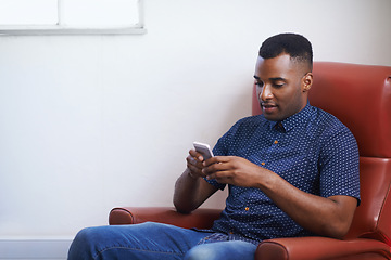 Image showing Man, phone and relax on social media at home, online and internet for website or blogging. Black male person, typing and streaming entertainment on armchair, texting and app for shopping on weekend