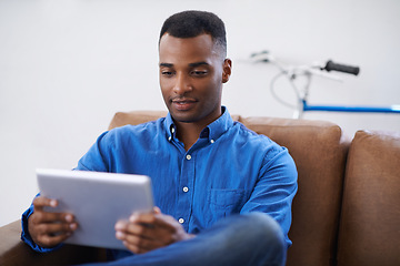 Image showing Man, tablet and online for website at home, games and internet for blog or movies. Black male person, subscription and streaming entertainment on couch, video call and app for shopping on weekend