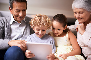 Image showing Happy family, grandparents and kids with tablet on sofa for entertainment or social media at home. Grandma, grandpa and children with smile, hug and love on technology for bonding or game at house