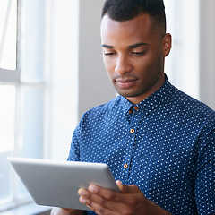 Image showing Businessman, tablet and online at window for communication, internet search and networking in office. Entrepreneur, african employee or serious with technology for corporate email or planning at work