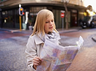 Image showing Woman, tourist and reading a map in city street for directions, travel or journey in Cape Town. German female, confused and holding a navigation chart in urban background on vacation, holiday or lost