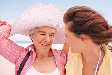 Image showing Smile, wind and senior mother on beach with daughter in summer for travel, holiday or vacation. Face, love or bonding with woman and happy elderly parent outdoor together for weekend getaway