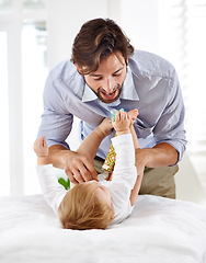 Image showing Father, baby and bonding with play in home for healthy development, parenting and changing diaper on weekend. Family, child and man with face, talking and toddler for relax, love and care in house
