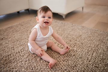 Image showing Happy, sweet and baby on carpet playing for child development in living room at house. Smile, cute and adorable young infant, toddler or kid sitting on floor rug for growth in lounge of modern home.