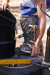 Image showing Person, hands and boots of professional motorcyclist preparing for race, competition or extreme sports. Closeup of dirt biker or rider checking foot for grip, safety or mobility on off road track