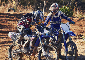 Image showing Sport, teamwork or racer on motorcycle outdoor on dirt road with support in driving, challenge or competition. Motocross, motorbike or dirtbike driver and helmet on offroad course or path for racing