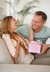 Image showing Man, present and surprise for woman with gratitude, happy people with love and trust at home. Anniversary, birthday or event, couple with secret gift box with thank you for celebration and romance