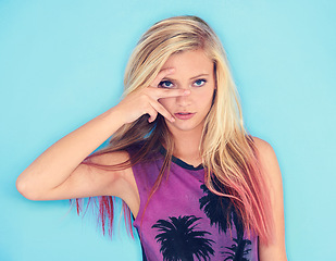 Image showing Portrait, fashion and woman in studio for confidence in blue background, hair dye and serious with trendy top. Female person, funky and style with outfit in streetwear for casual and stylish clothes