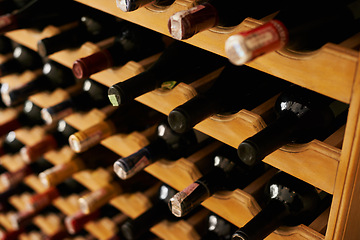 Image showing Wine cellar, bottle and storage on rack in basement for restaurant stock, winery and shelf with alcohol display. Warehouse, drinks collection and beverage stack in vineyard with arrangement and row