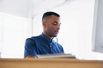 Image showing Businessman, thinking and working in office by desk, planning and commitment with ambition in career. Entrepreneur, idea and typing on desktop on technology and project management in small business