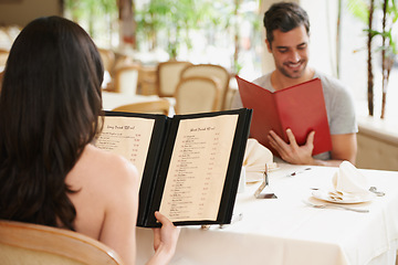 Image showing Couple, restaurant and menu for food decision, fine dining and bonding on valentines day. People, love and romance at cafe or lunch choice for anniversary celebration, cuisine and happy at bistro