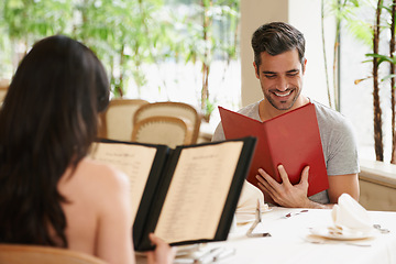 Image showing Happy couple, date and reading menu at restaurant for fine dining, romance or ordering food together. Young man and woman looking at brochure with smile for meal, dinner or decision in eating choice