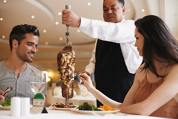 Image showing Couple, waiter and service for lunch in restaurant with meat, happiness and fine dining for anniversary or honeymoon. Man, woman and employee with steak on skewer, healthy meal and table in London