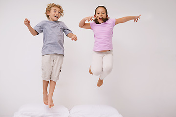 Image showing Jumping, bed and kids with fun, energy and morning in a bedroom with game and sibling. Youth, hop and home with a excited children on a duvet in air with crazy play and leap in house with friends