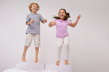 Image showing Jumping, bed and kids with happy, funny and morning in a bedroom with game and sibling. Youth, hop and home with excited children in air with crazy, play and laugh with energy in house with family