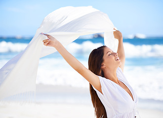 Image showing Sea, happy woman and fabric in wind at beach outdoor for summer, vacation and travel on holiday. Ocean, smile and person fly with silk sarong in the air for adventure, freedom or calm breeze by water