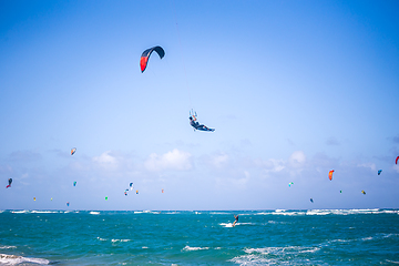 Image showing Kiteboarding. Fun in the ocean. Extreme Sport Kitesurfing. Kitesurfer jumping high in the air performing triks during kitesurfing session.