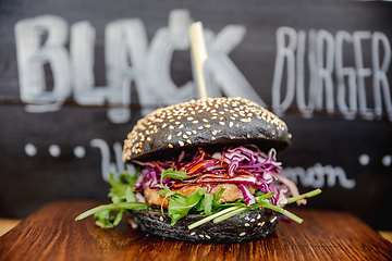 Image showing Fresh colorful vegan burgers with vegetables on counter at summer local food market - close up view. Outdoor cooking, gastronomy, vegetarian, street food concept.