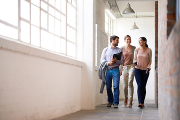 Image showing Business people, walking and team in discussion at office with coffee in startup at hallway. Smile, group and employees in corridor for conversation, meeting or creative designers laughing on break