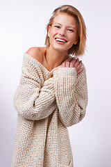 Image showing Woman, winter fashion and portrait in studio for clothing or style on white background or backdrop. Model, smile and pose while isolated for casual, jersey and trendy wear for comfort in Dublin