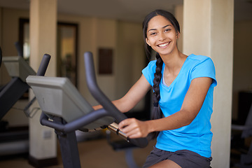 Image showing Woman, portrait and exercise bike in gym, cycling and stationary machine for workout at club. Female person, cardio and cycling for strength training, smile and equipment for fitness and health