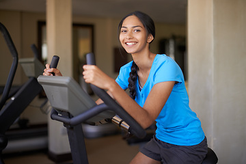 Image showing Woman, portrait and workout bike in gym, cycling and stationary machine for exercise or training. Happy female person, cardio and cycling for wellness, smile and equipment for fitness and health