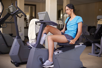 Image showing Woman, fitness and exercise bike in gym, wellness and stationary machine for workout at club. Female person, cardio and cycling for strength training, athlete and equipment for challenge and health