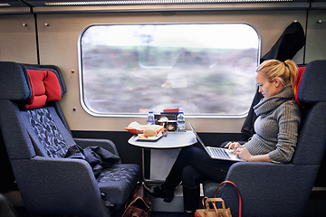 Image showing Woman, train and travel with laptop on journey or research project on commute for destination, transportation or internet. Female person, railroad and passenger in Canada for comfort, tourist or trip