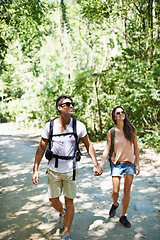 Image showing Walking, hiking and couple holding hands in nature for adventure, freedom and backpacking outdoors. Travel, bonding and man and woman on trail for holiday, vacation or trekking for wellness in forest