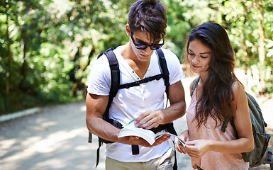 Image showing Couple, map and search for hiking in forest with reading for thinking, holiday and ideas on path. Man, woman and bag for trekking, direction and journey in jungle with book for location in Colombia