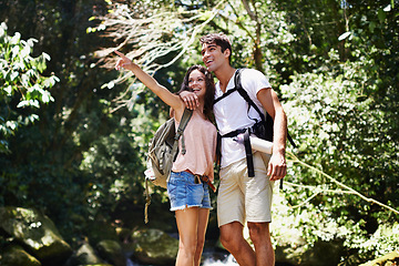 Image showing Hiking, pointing or happy couple hug in nature, forest or park on a trekking adventure on holiday. Man, woman or romantic people in woods for travel or journey with care, love or wellness on vacation